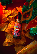 Load image into Gallery viewer, That Juan Cerveza Hot Sauce bottle with a mask and tortilla chips on a red surface