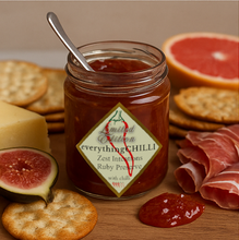 Load image into Gallery viewer, Zest Intentions Grapefruit &amp; Rosemary preserve, opened with a spoon in the jar, set beside crackers and cheese, proscuittio and a fig
